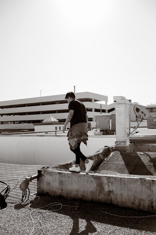Sepia Toned Photo of a Man Walking on a Rooftop