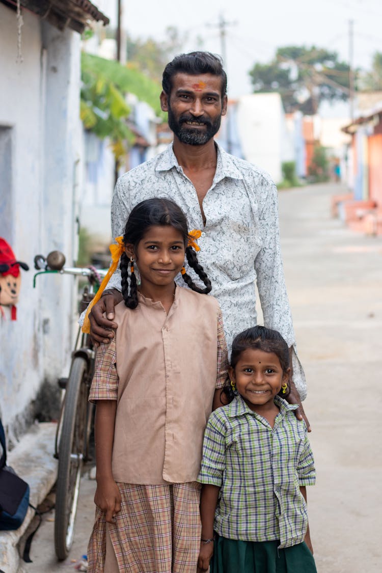 Man Standing With His Two Daughters 