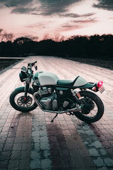 Classic motorcycle on a scenic brick road with a sunset backdrop, highlighting adventure and freedom.