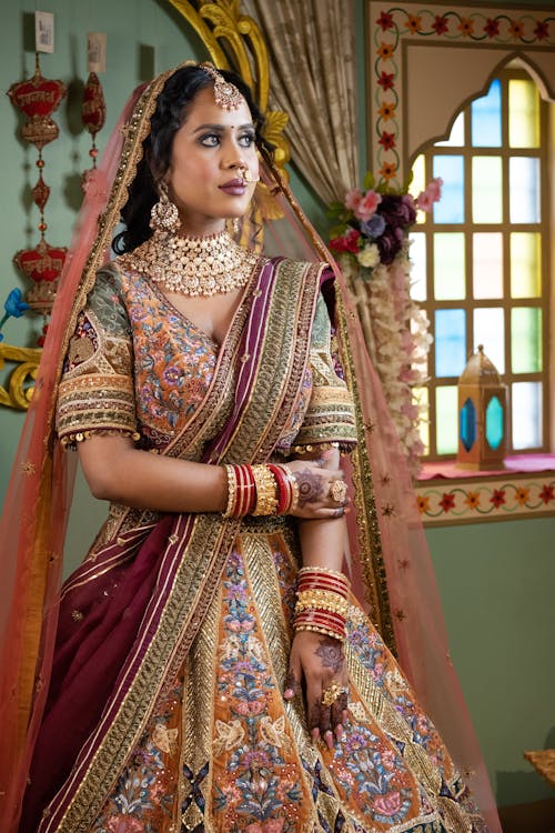 Photo of a Woman Wearing Decorative Traditional Clothing, and Decoration Hanging in Background