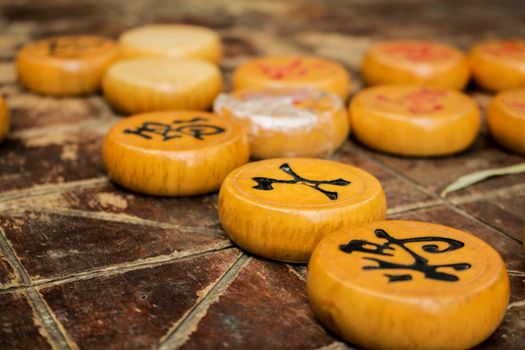 Detailed close-up of traditional Xiangqi (Chinese Chess) pieces on a wooden board.