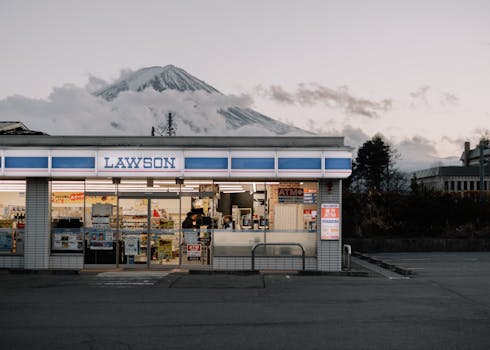 Lawson store with Mount Fuji in the background during day, showcasing urban convenience and natural beauty.