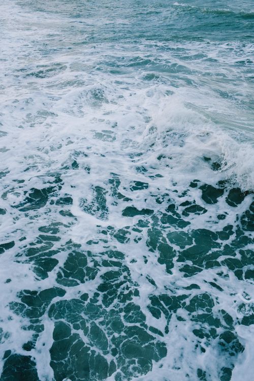 Free Captivating view of ocean waves creating a beautiful sea foam pattern, highlighting nature's power and tranquility. Stock Photo