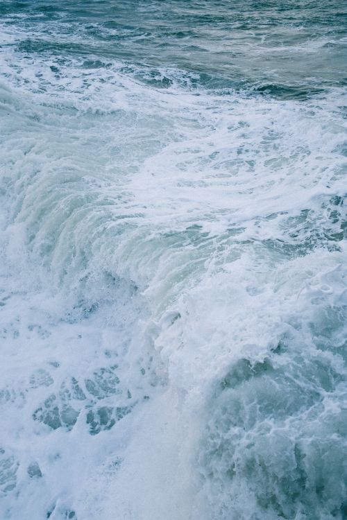 Free Captivating close-up of turbulent sea waves with foamy crests crashing against a shore. Stock Photo