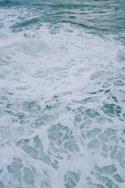 Free Dynamic ocean surface with frothy white waves in motion, perfect for nature and travel themes. Stock Photo