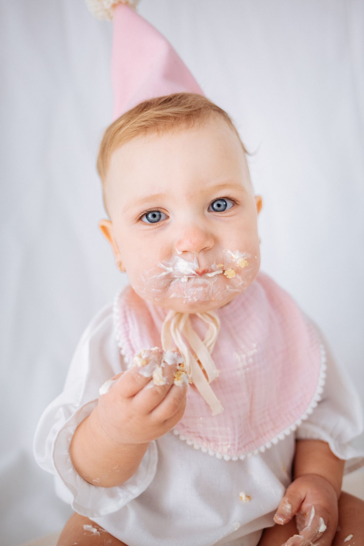 Baby with frosting on their face during a cake smash close-up
