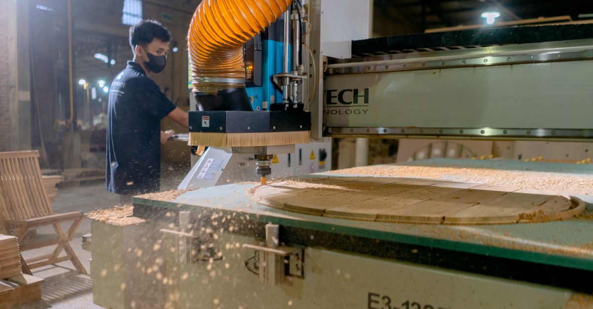 Carpintero operando una máquina CNC en una fábrica de madera moderna