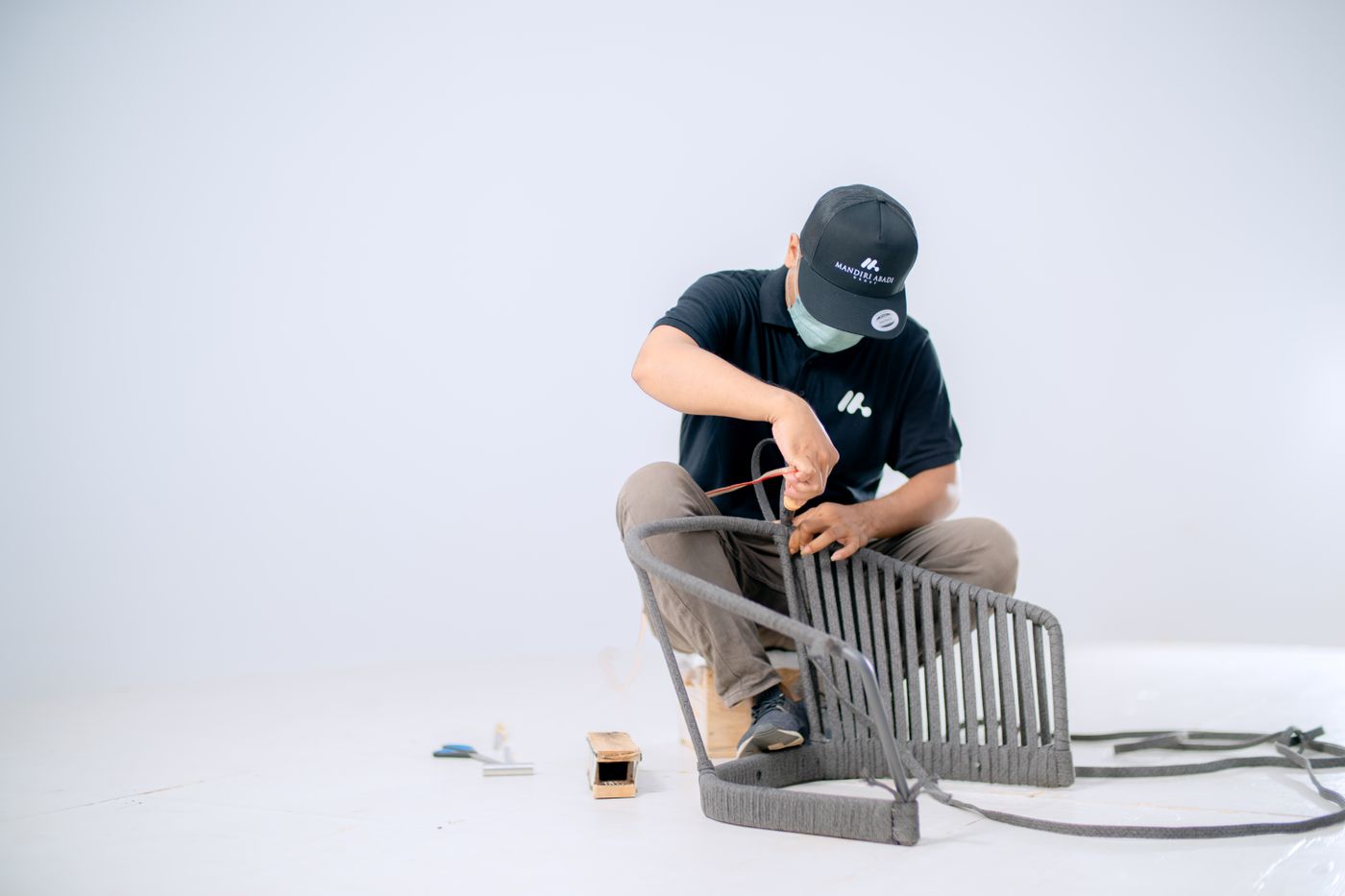 Craftsperson assembling a wooden chair in a furniture workshop