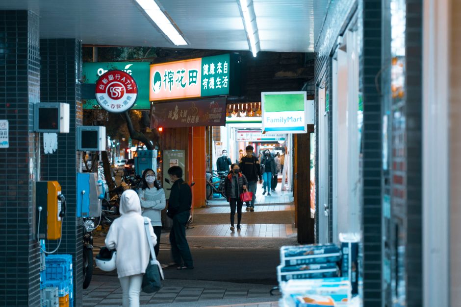 ショップと忙しい歩行者がいる明るい通路の賑やかな都市シーン。