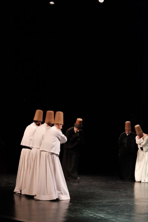 Free Mevlevi dervishes in traditional attire performing Sema dance on stage in Istanbul. Stock Photo
