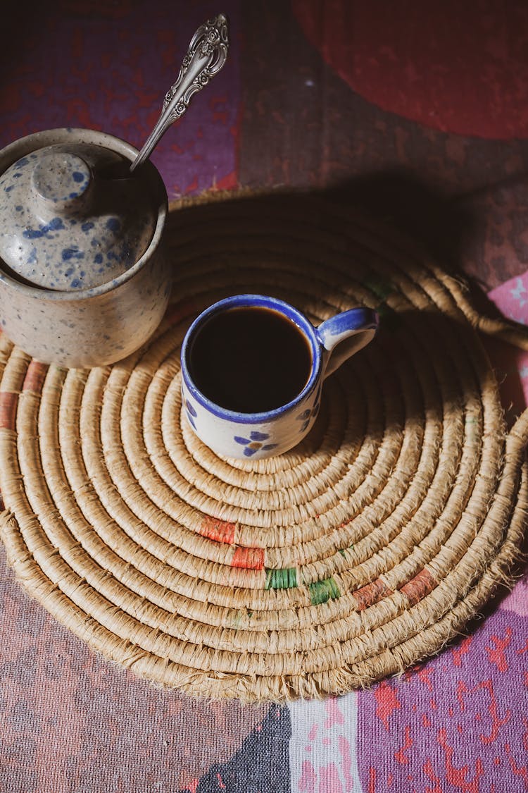 A Cup Of Black Coffee Over A Placemat