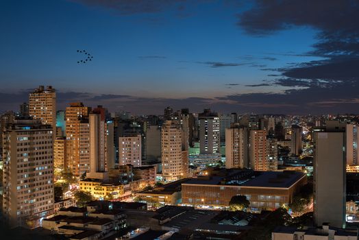 Aerial view of illuminated buildings in Belo Horizonte, Brazil, at dusk.