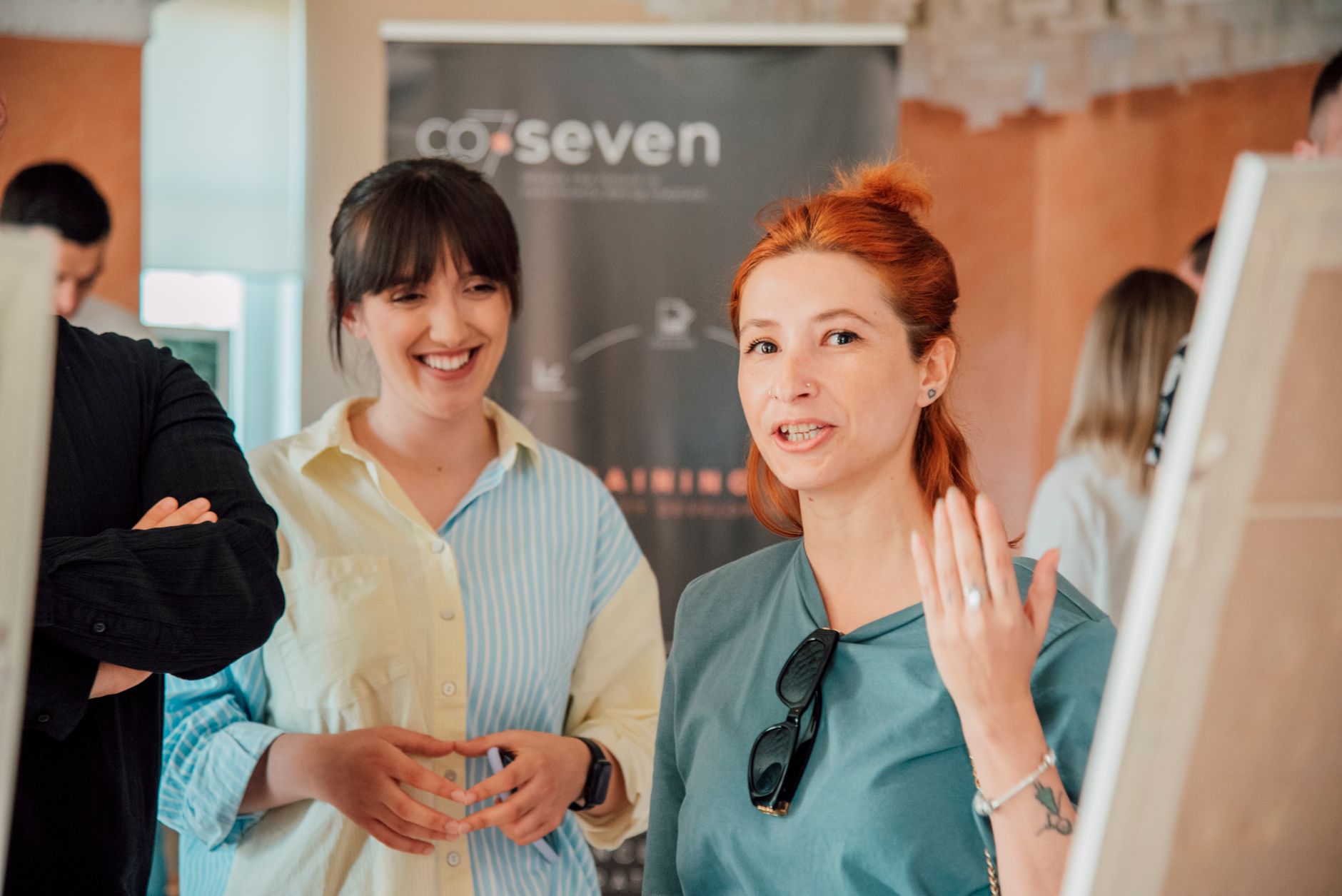 Creative professionals engaging in conversation at a networking event, exchanging ideas and business cards in a vibrant, collaborative atmosphere.