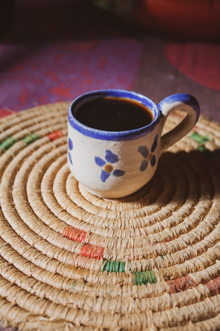 A Cup Of Hot Coffee Over A Placemat