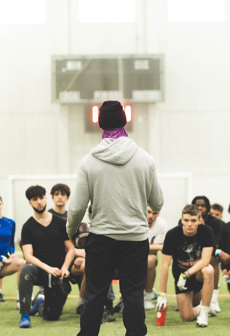 A Man In Gray Hoodie Talking To His Team