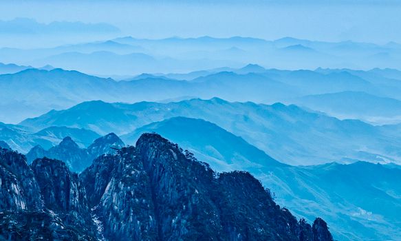 Stunning panoramic view of layered mountain ranges under a blue sky.