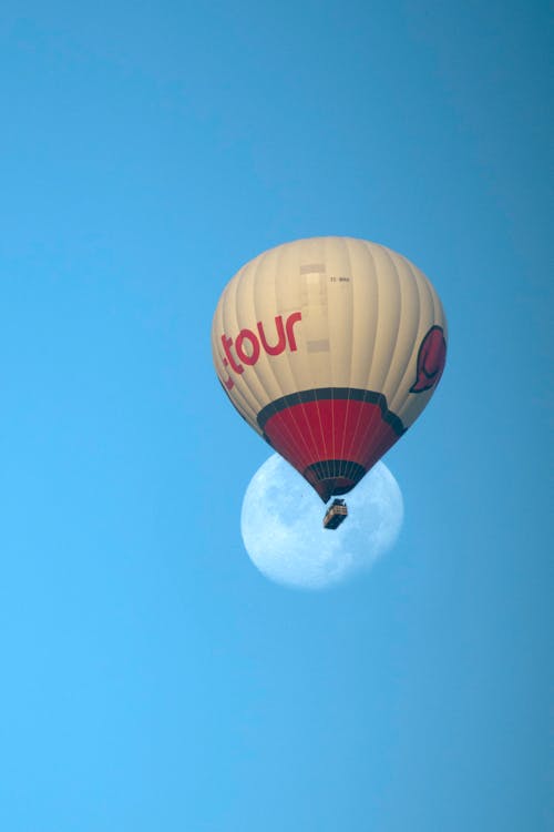 A Hot Air Balloon against a Blue Sky and the Moon 