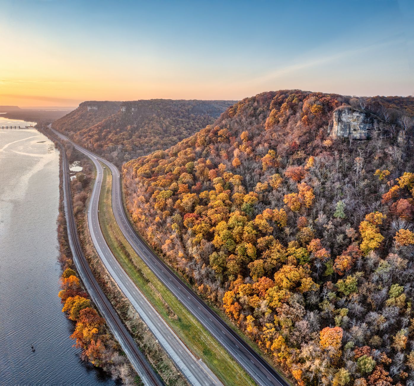 Breathtaking aerial view of a winding highway through autumn trees in Minneiska, Minnesota.