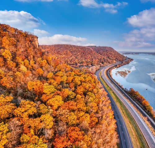 Free Stunning aerial view of vibrant autumn forest beside highway and river in Minneiska, Minnesota. Stock Photo