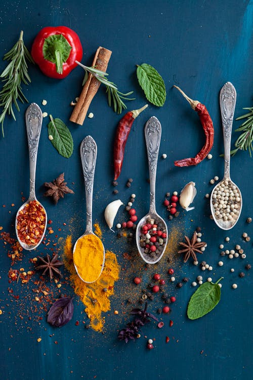 Four Spoons with Spices on Blue Table