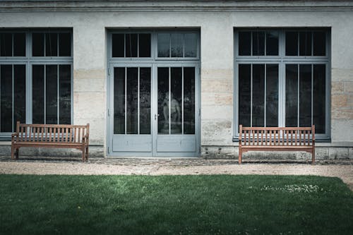 Two Wooden Benches Outside of a Building 