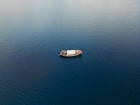 Aerial view of a small boat floating in the calm waters of the Adriatic Sea near Mali Iž, Croatia.