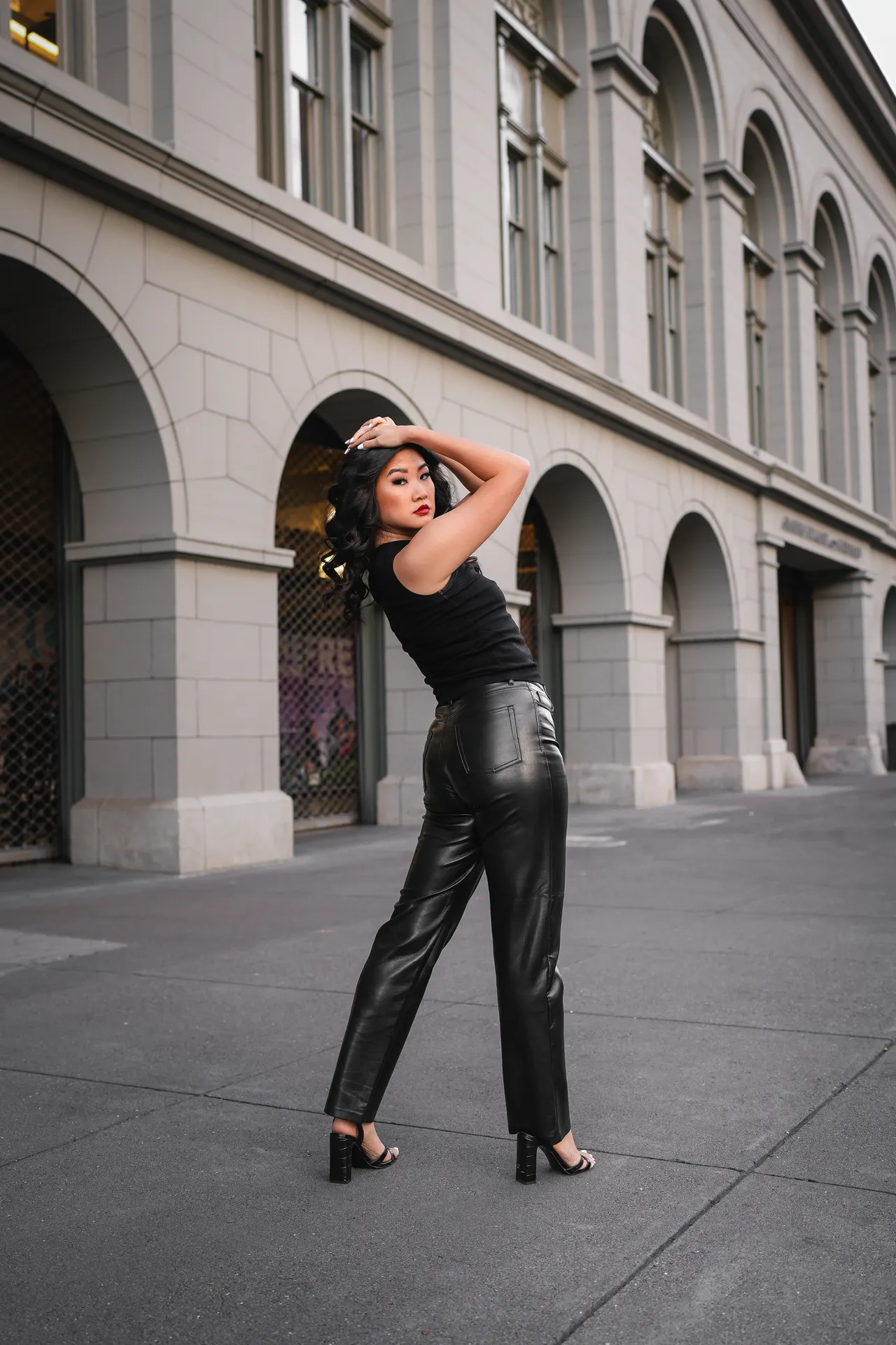 faux-leather-pants-black-top-airport Woman in black faux-leather pants with a black top, an edgy airport outfit idea