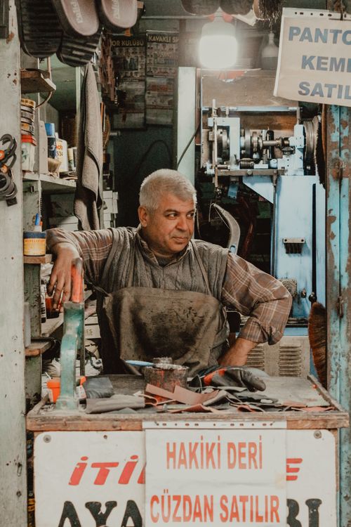 Free Authentic image of a shoemaker working in his workshop with tools and leather crafts around. Stock Photo