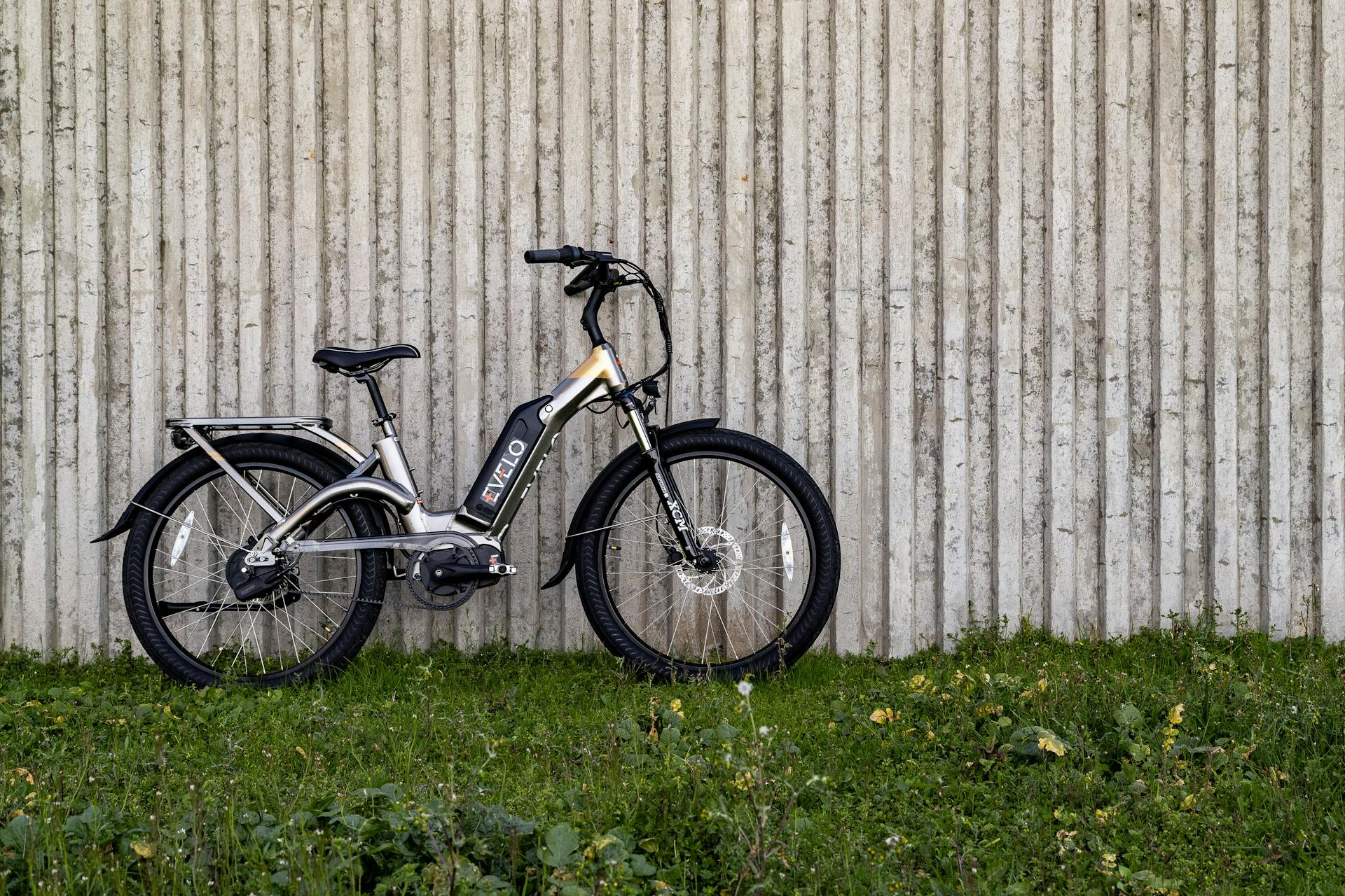Black Bicycle Parked Beside a Concrete Wall