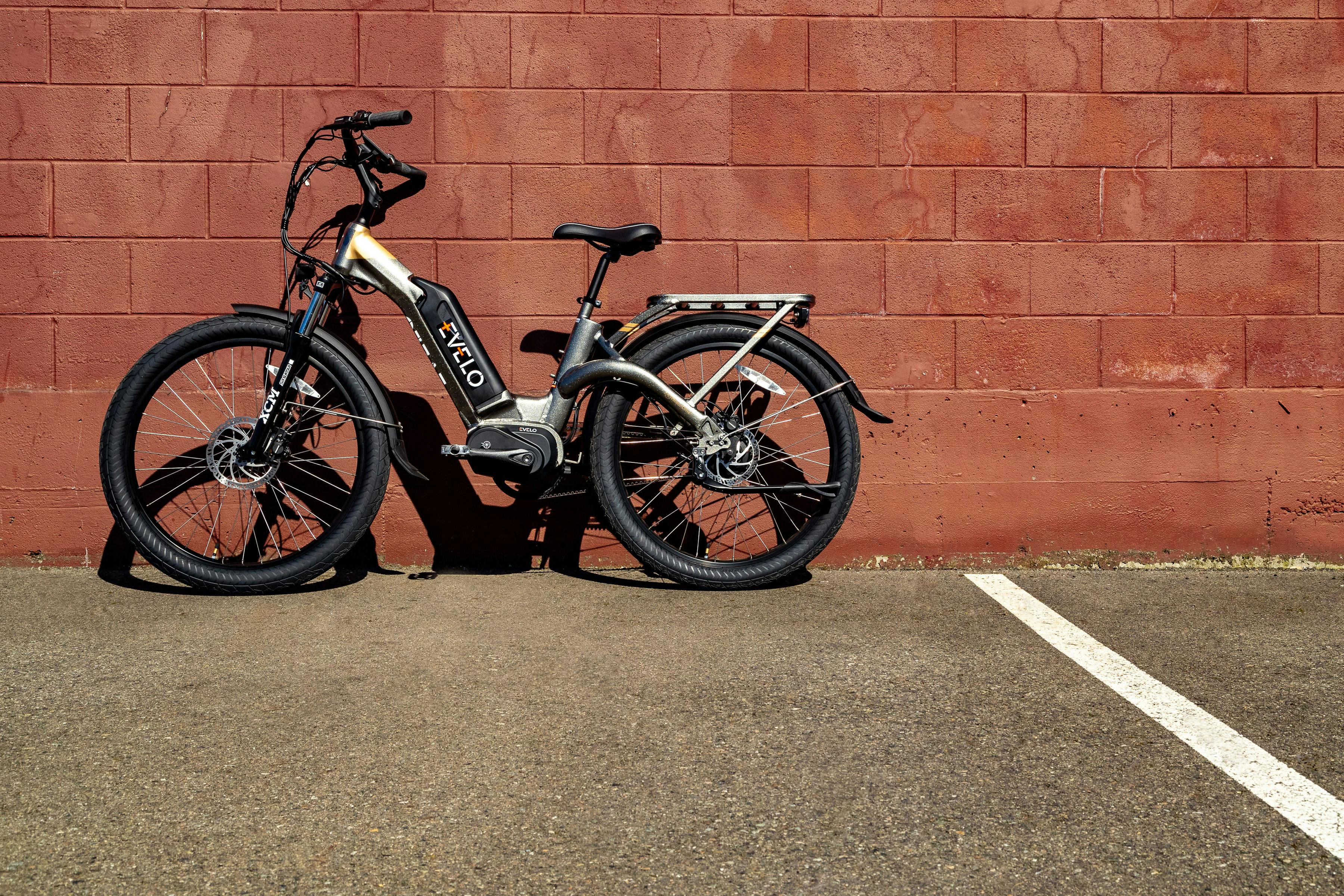 Free Electric bike resting against a red brick wall on a sunny day in Seattle. Stock Photo
