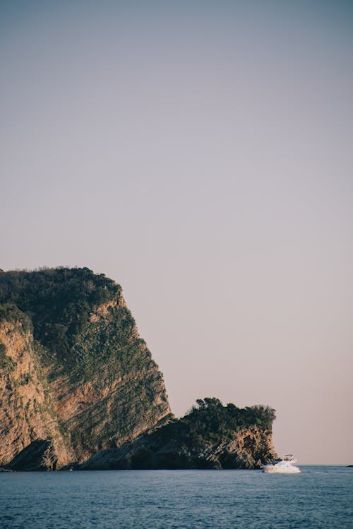 Cliff with Green Trees Near Body of Water