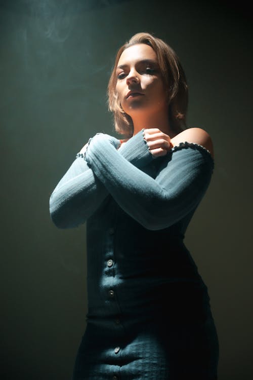 Woman in Dress Posing in Dark under Light