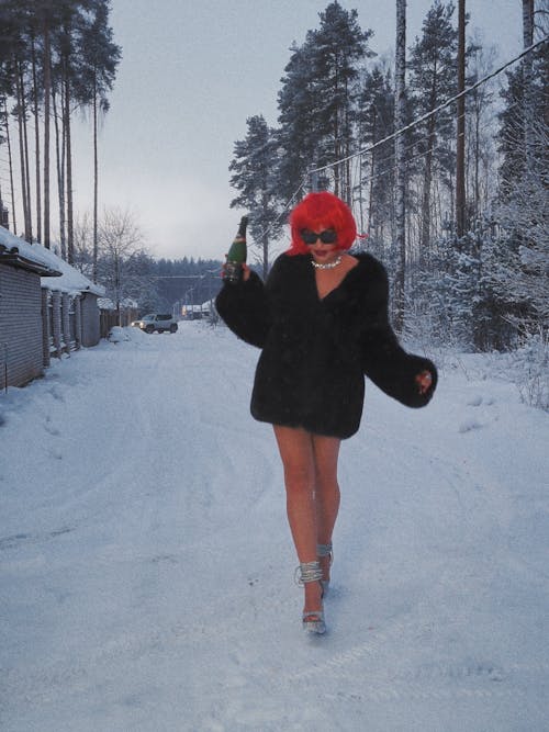 Walking Woman on Snow Holding a Bottle