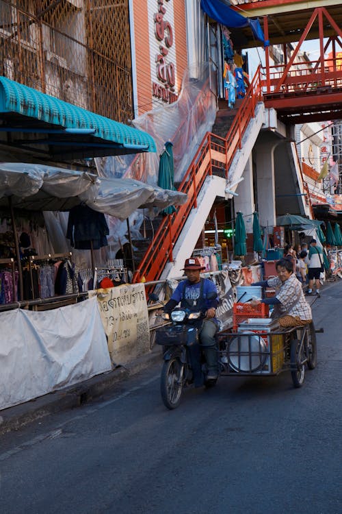 People Riding Bike with Carriage on City Street