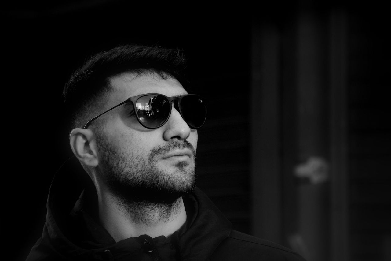 moody monochrome portrait featuring a bearded man in sunglasses