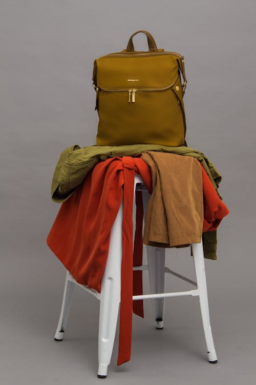 Free テキスタイルとスツールの上に茶色のバッグ Stock Photo