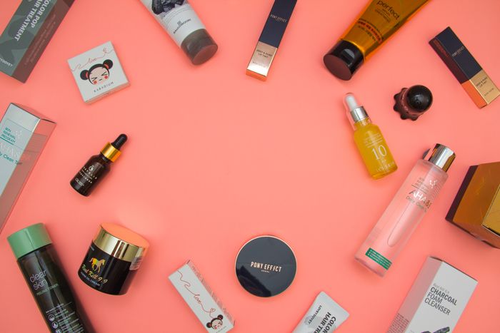 Beauty products arranged on a pink surface. Photo: Ray Piedra on Pexels.
