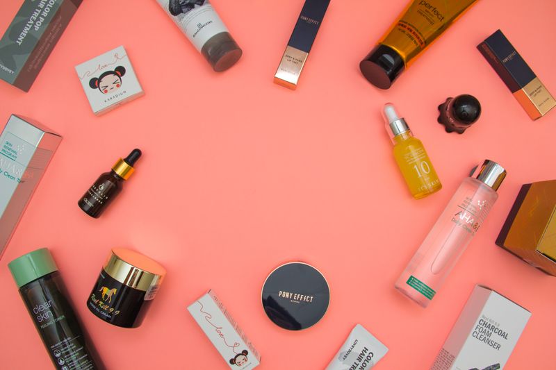 Productos de belleza sobre mesa rosa