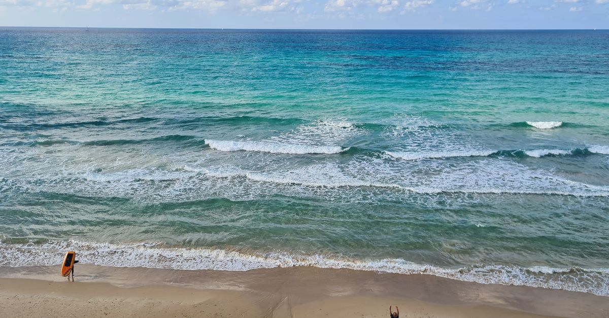 Aerial view of waves crashing on Herzliya beach in Israel, showcasing serene coastal scenery.
