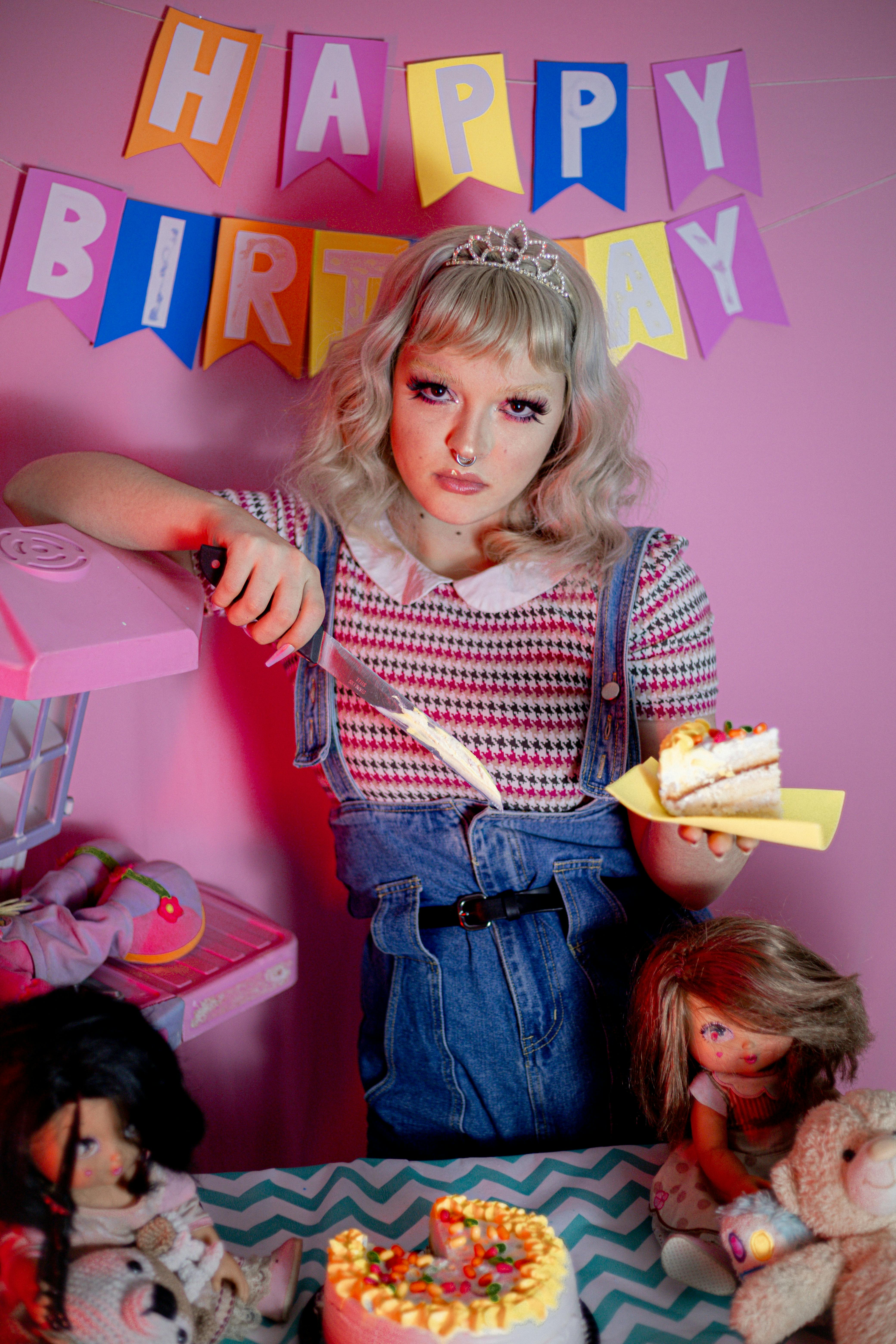 blonde with knife over birthday cake