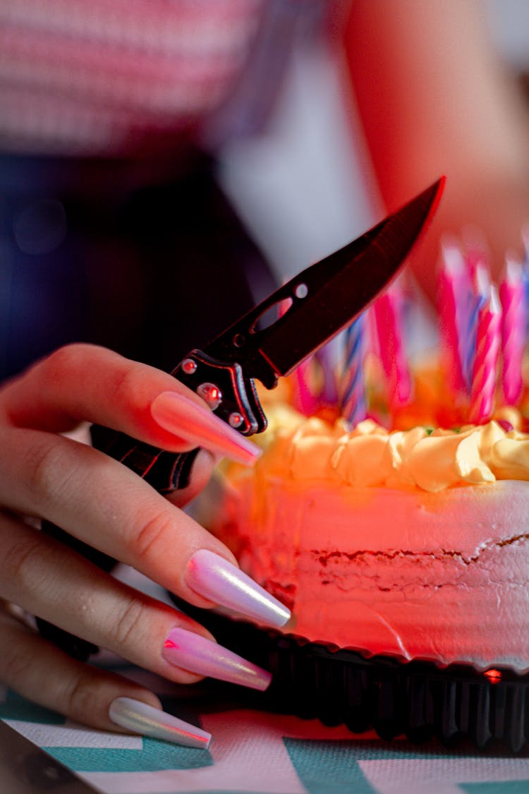 Hand Holding Knife By Birthday Cake