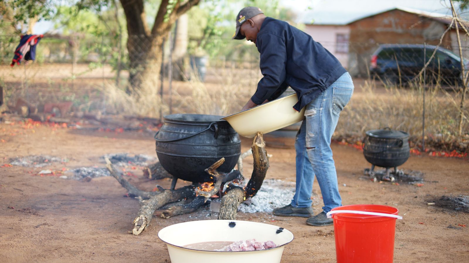 Man cooking in cauldrons, Botswana