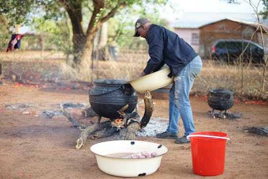 A man prepares food in cauldrons over a fire in Gaborone, Botswana.