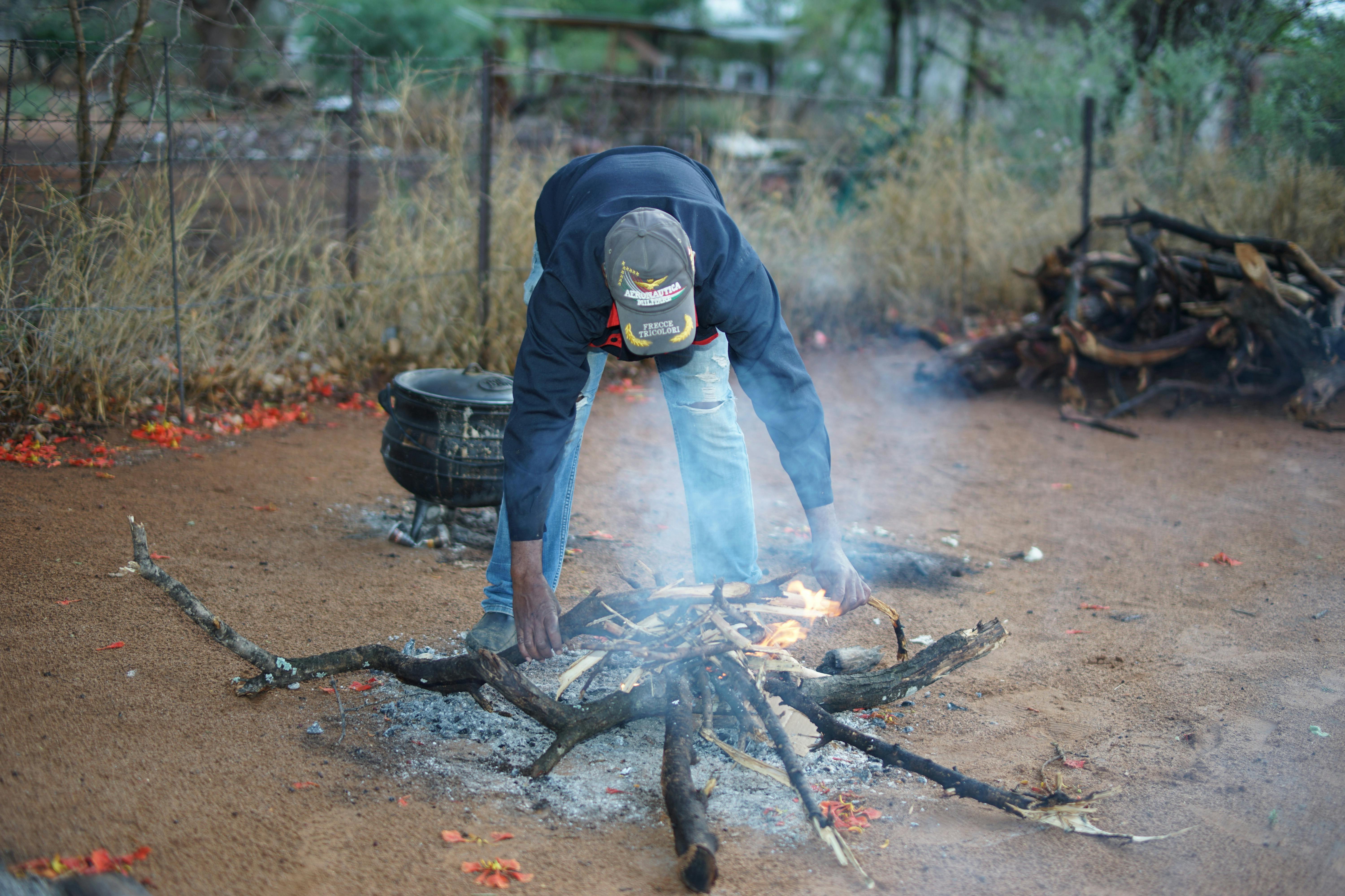 Man Bending over Bonfire · Free Stock Photo