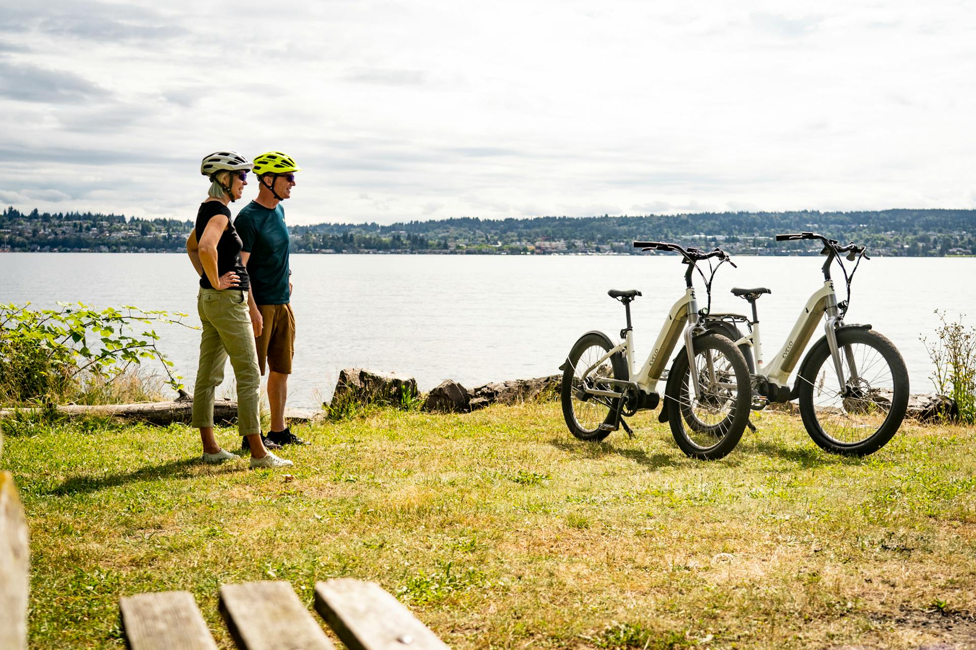 A Couple Standing on Green Grass Near Electric Bikes