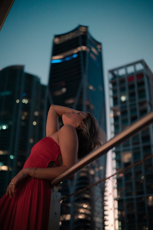 Woman in Red Dress Posing with Skyscrapers behind