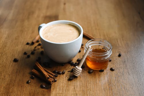 Free Photo of a Cup of Coffee Beside a Jar of Honey Stock Photo