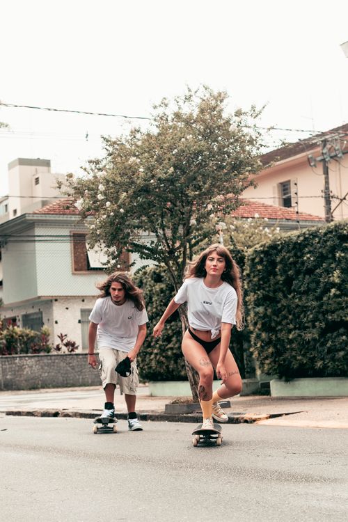 Free Two teenagers skateboarding on a city street in Santos, Brazil, demonstrating urban youth culture. Stock Photo
