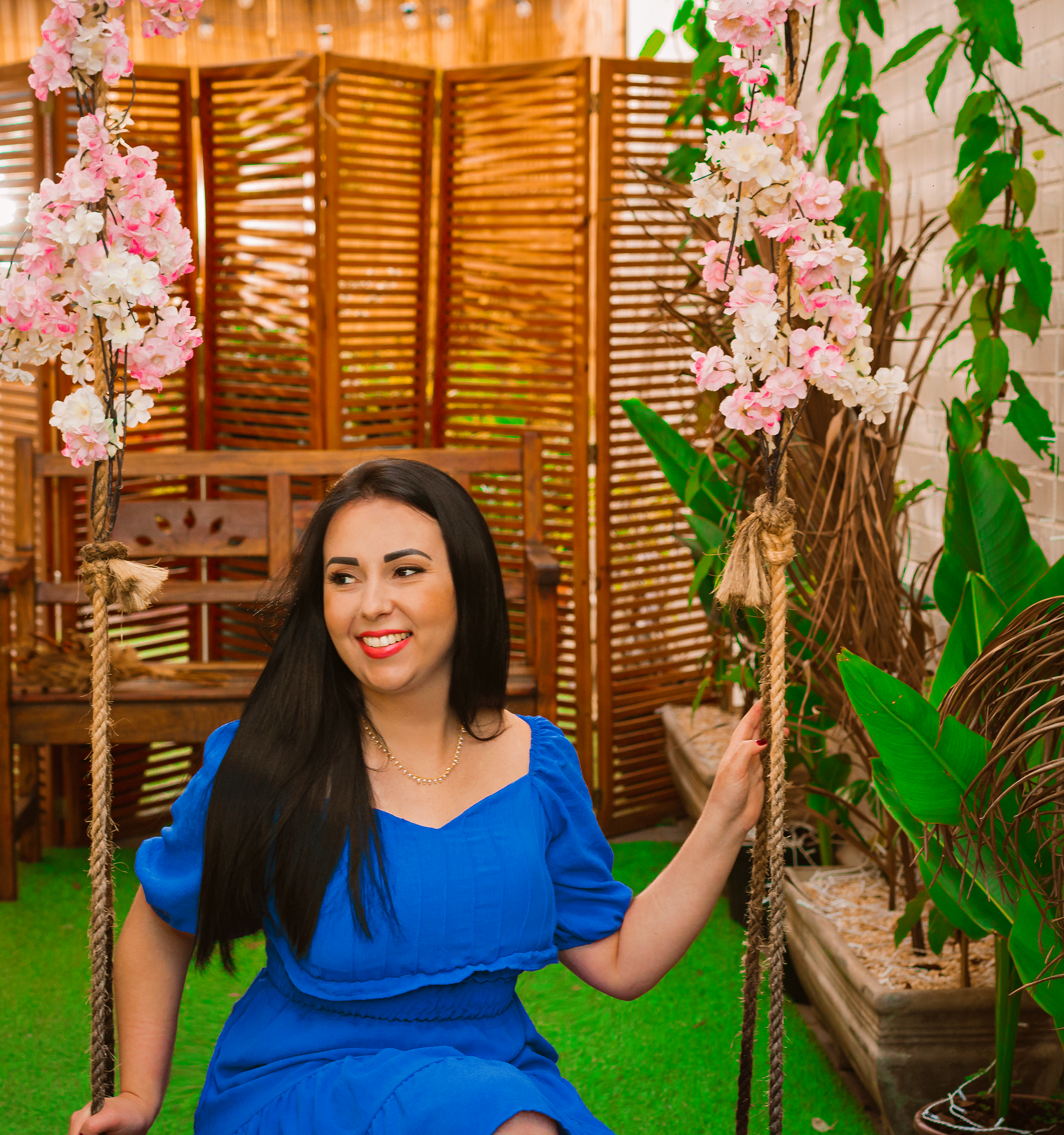 A Woman in a Blue Dress Sitting on a Hanging Chair · Free Stock Photo