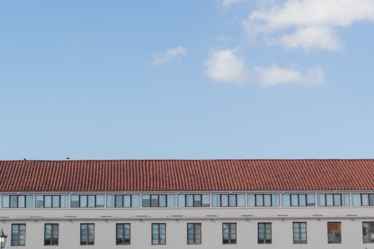 A crisp view of a modern building with a red roof and blue sky in Panama City.